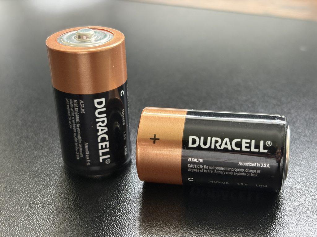 Two Duracell batteries with a black backgraound